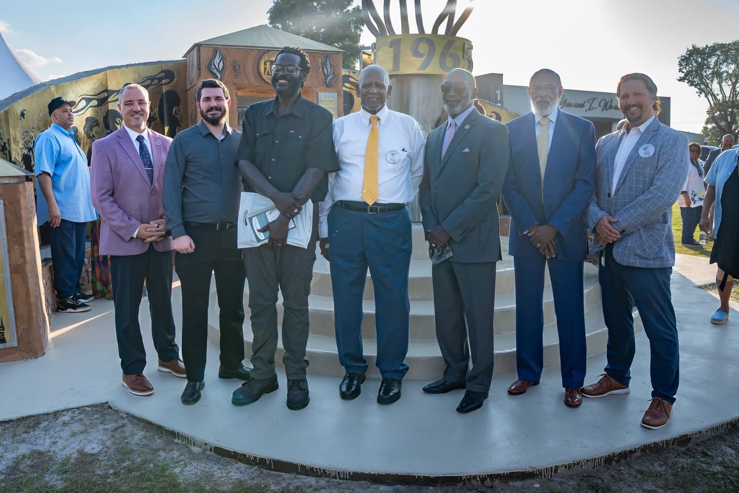 Derrick Monk standing with district leaders and supporters at the memorial