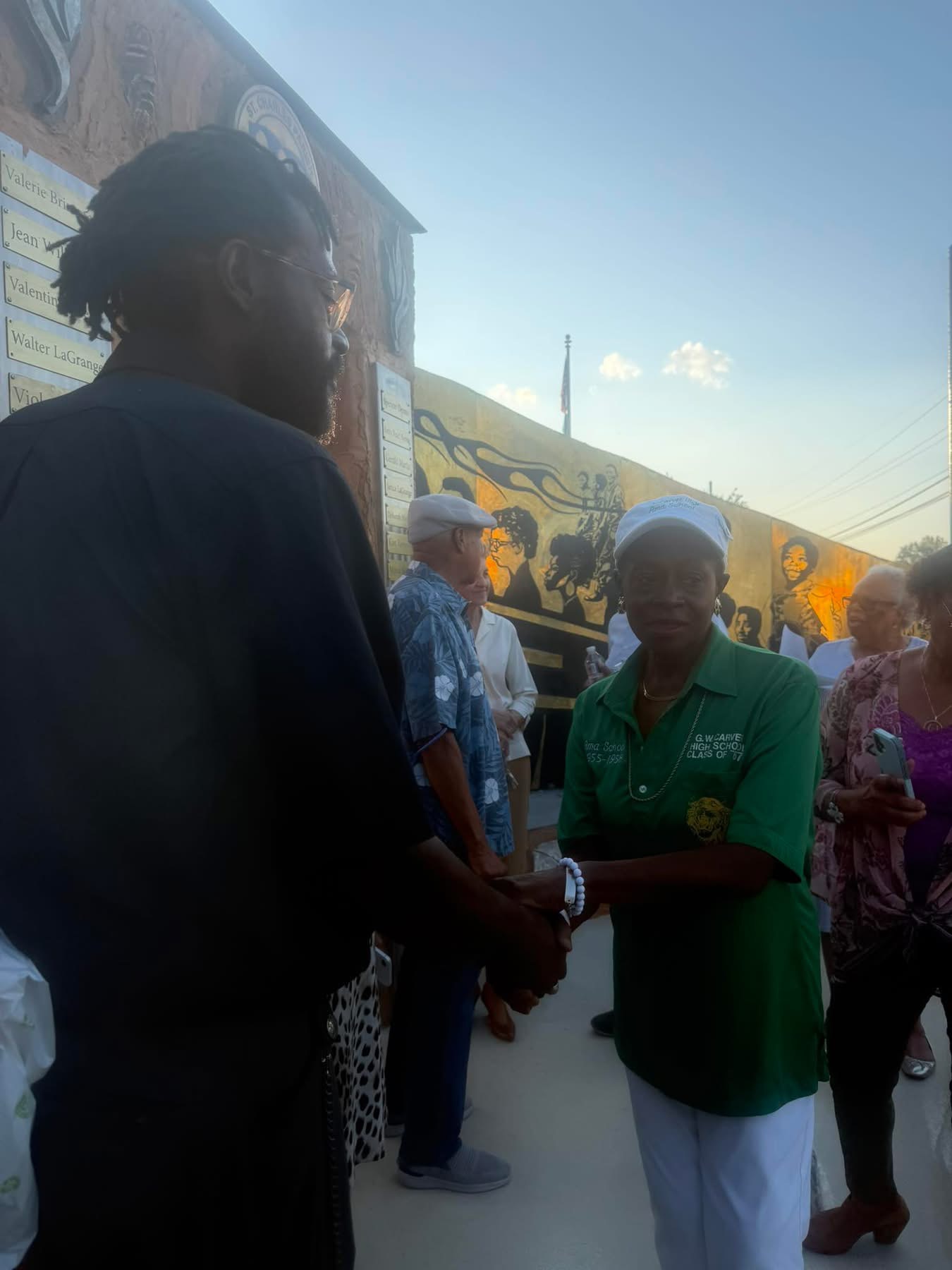 Derrick Monk greeting a G. W. Carver High School alumna at the dedication