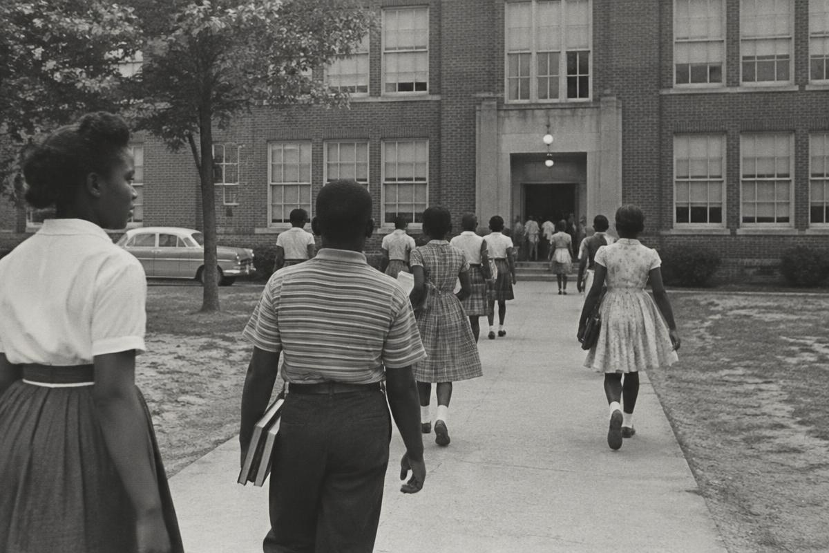 Black schoolchildren walking toward a public school building in the 1960s American South